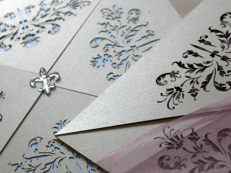 Couture invitations feature a delicate laser cut French pattern - blue and purple