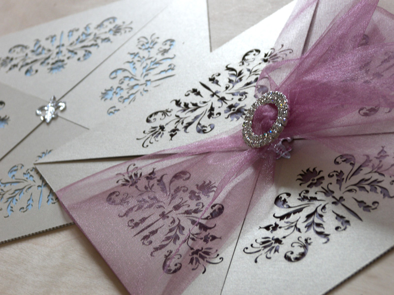 Couture invitations feature a delicate laser cut French pattern - purple