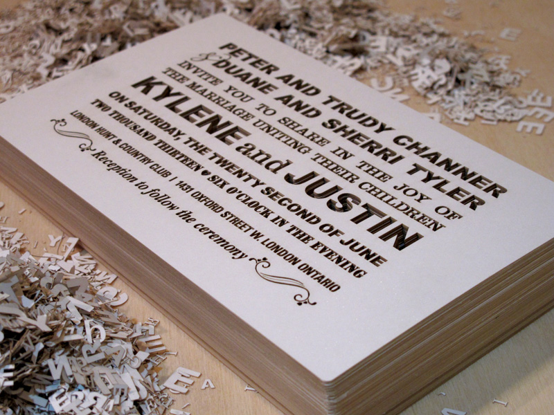 Stack of Fontography design laser cut wedding invitations