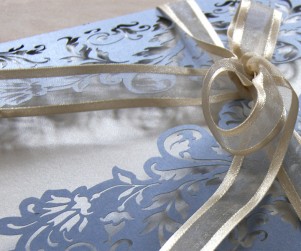 Close up on ribbon of French Flair laser cut wedding invitation