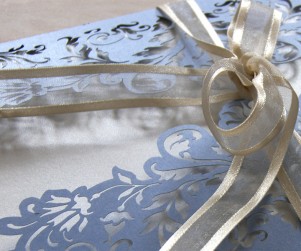 Close up on ribbon of French Flair laser cut wedding invitation