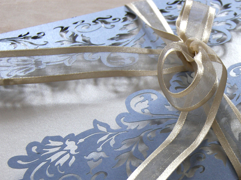 Close up on ribbon of French Flair laser cut wedding invitation