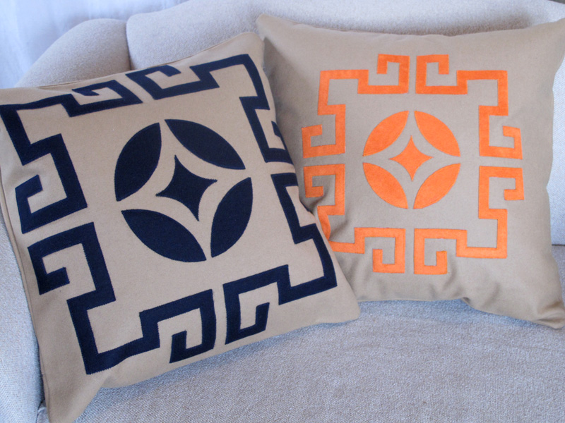 Laser cut throw pillows in navy blue and orange
