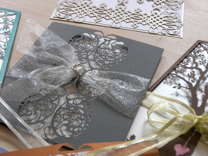 varying styles and colours of laser cut wedding invitations